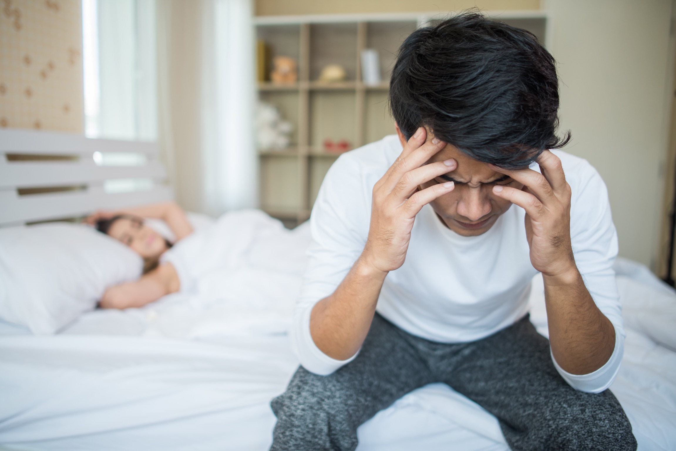 man having headaches with woman on the background